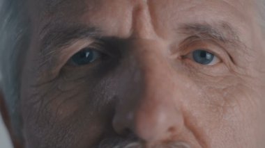 Komuta sizde gözünde yakından kameraya beyaz arka plan görünüyor.