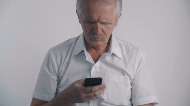 콧수염 스마트폰을 사용 하 여 흰색 배경에서와 수석 남자의 초상화 — 비디오