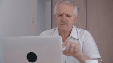 Gri saçlı komuta sizde dizüstü ofiste çalışan ve kahve içme bıyıklı