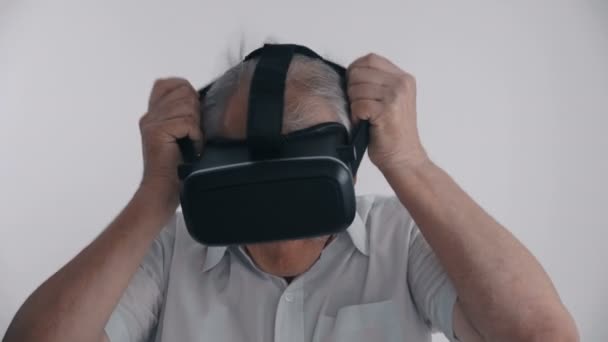 Starší muž pomocí jeho Vr headset pro sledovat 360 video na bílém pozadí — Stock video