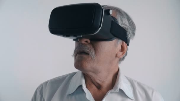 Starszy człowiek, za pomocą jego Vr zestaw słuchawkowy do oglądania filmu 360 w tle — Wideo stockowe