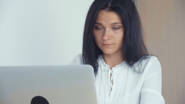 Primer plano de una joven exitosa chica de negocios en la oficina, trabajando con el ordenador portátil — Vídeos de Stock