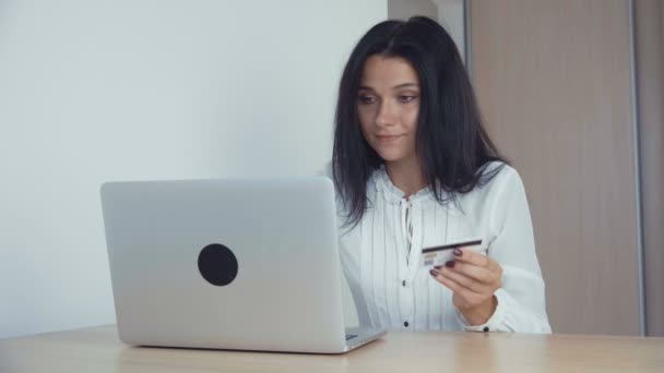 Mujer de negocios de compras en línea con tarjeta de crédito y portátil en la oficina — Vídeos de Stock