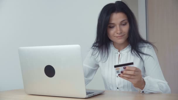 Бізнес-леді купує в Інтернеті з кредитною карткою і ноутбуком в офісі — стокове відео