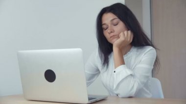 Laptop ofiste çalışan sıkılmış kadın