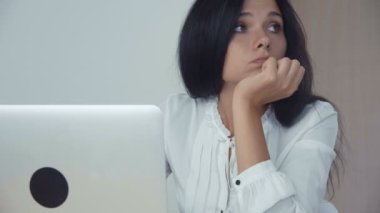 Dizüstü ofiste çalışan sıkılmış iş kadını