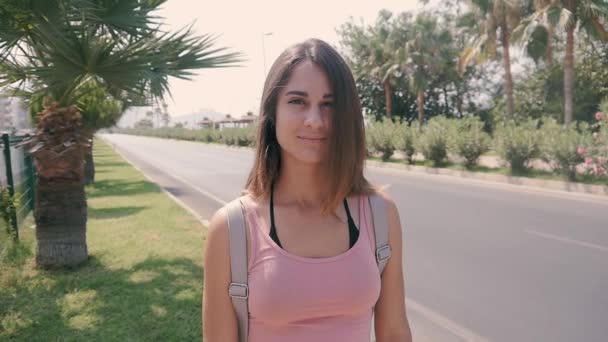 Retrato de la joven mujer bonita en la calle de la ciudad en verano caliente en el complejo tropical — Vídeos de Stock