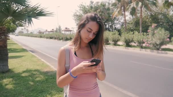 Портрет молодої красивої жінки на міській вулиці, використовуючи смартфон в спекотне літо на тропічному курорті — стокове відео