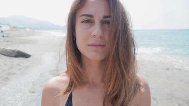 Портрет молодой женщины на пляже у моря — стоковое видео
