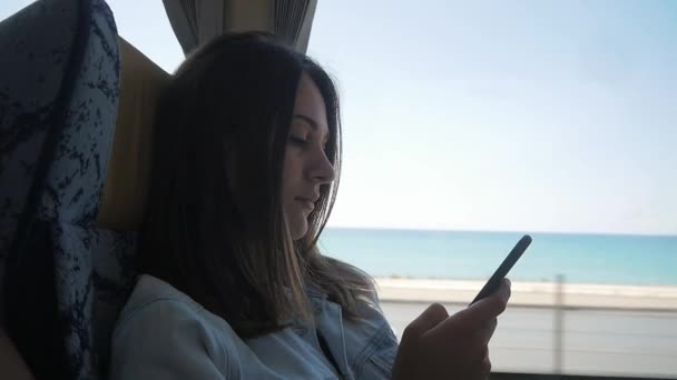 Jovem mulher usando smartphone durante o passeio de ônibus — Vídeo de Stock