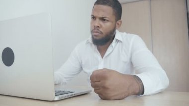 Kızgın Afro-Amerikan patron masaya yumruk atıyor. Şiddet tehdidi. Patron saldırganlık gösterir.