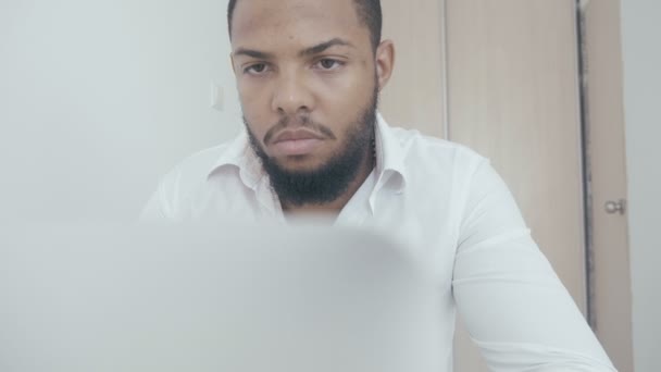 Ernstige zwarte man werken gebruik computer Zoek in beeldscherm op kantoor. Worling van de Afro-Amerikaanse zakenman op laptop. — Stockvideo