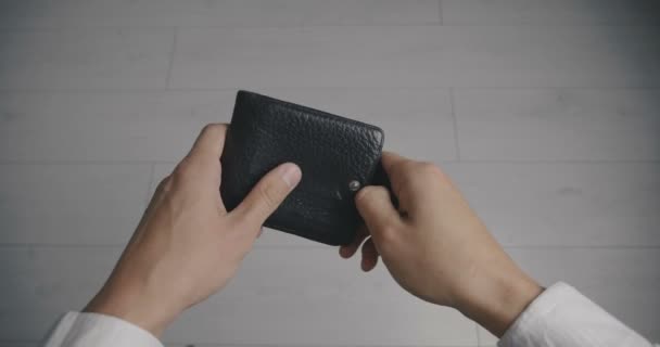 お金なしで空の革財布を保持する人の手のクローズアップ。貧困の概念 — ストック動画