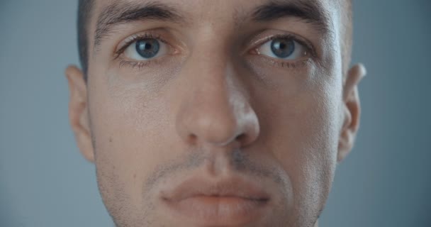 Portret van het gezicht van jonge man op een neutrale achtergrond — Stockvideo