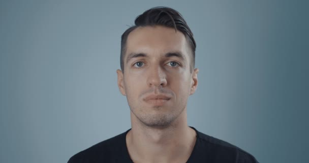 Porträtt av ung man på en neutral bakgrund — Stockvideo