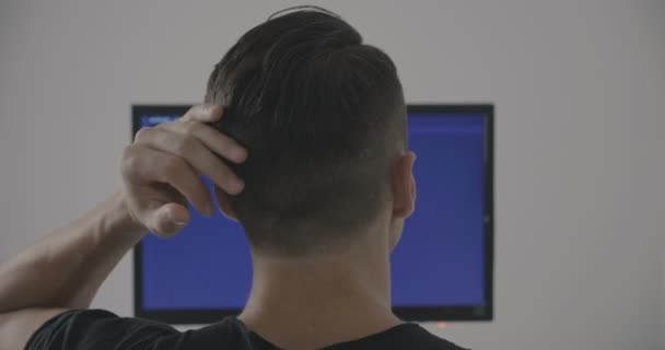 Vista posterior del programador del hombre que trabaja en la computadora en la oficina — Vídeos de Stock