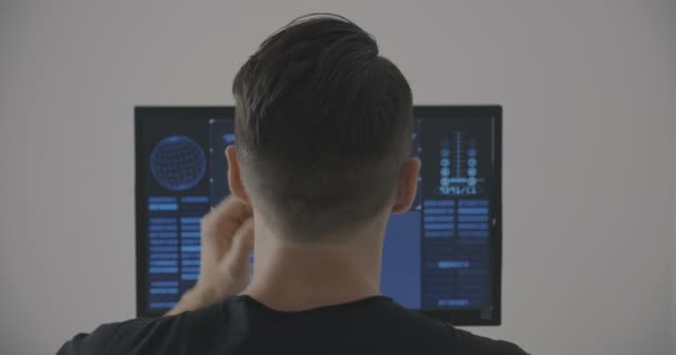 Achteraanzicht van man programmeur, werken op computer op kantoor — Stockvideo