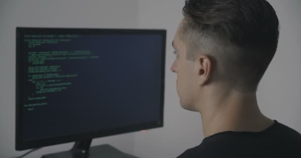 オフィスのコンピューターで働いている間緑のコードを記述しているハッカー プログラマ — ストック動画