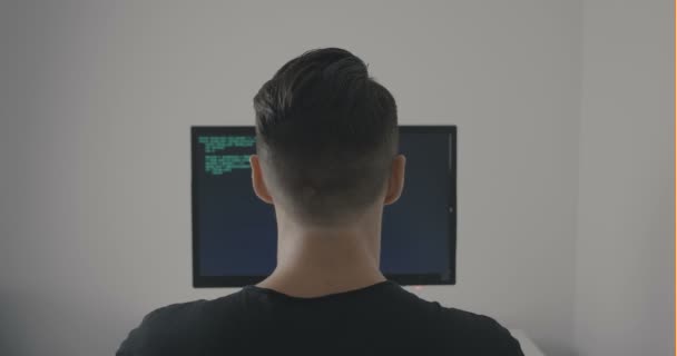 Rückansicht eines Hacker-Programmierers, der grünen Code schreibt, während er am Computer im Büro arbeitet