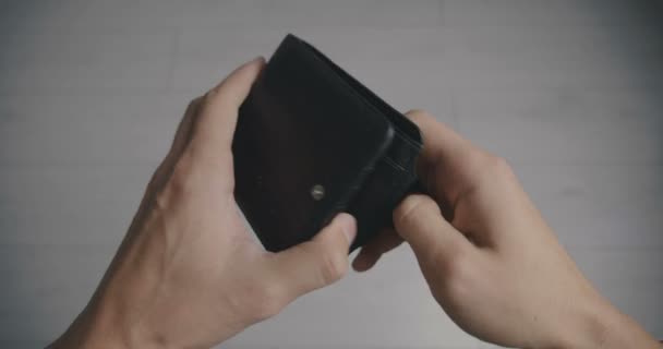 Primer plano de una mano de hombre sosteniendo Cartera de cuero vacía sin dinero. El concepto de pobreza — Vídeos de Stock