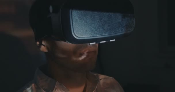 Giovane uomo guardando video con VR realtà virtuale hemlet di notte a casa — Video Stock