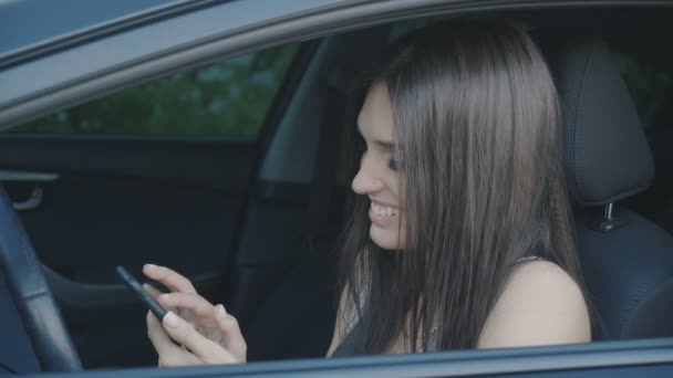 Junge schöne Frau benutzt ein Smartphone, während sie im Auto sitzt — Stockvideo