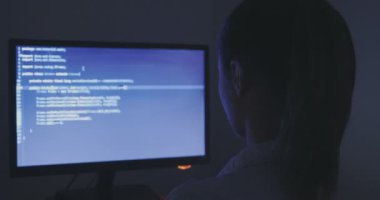 portre ile dolu veri merkezindeki bir bilgisayarda çalışan genç kadın programcı görüntüleme ekranları