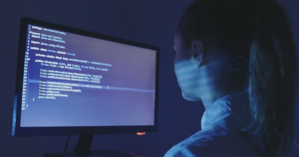 Portrét mladé ženy hacker programátor pracuje u počítače v noci v datovém centru. Pohled zezadu. — Stock video