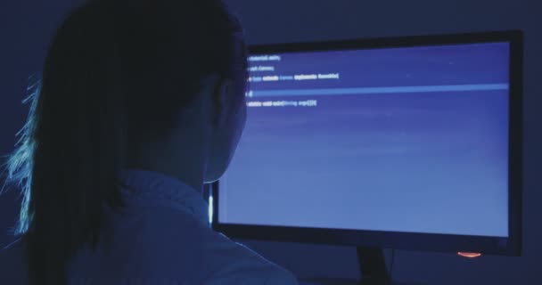 Porträtt av ung kvinna hacker programmerare arbetar på en dator på natten i datacenter. Bakifrån. — Stockvideo