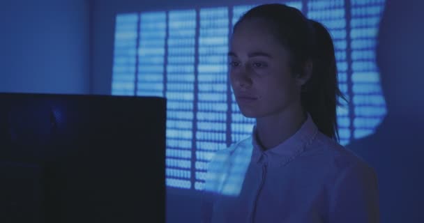 新しいプログラムの女性プログラマーの作品はそれを経験しました。若い女性ハッカーは、暗い部屋でソフトウェアのソースコードを作成します。. — ストック動画