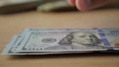 Yakın çekim yüz dolar faturaları bir masada sayma businessmans eller