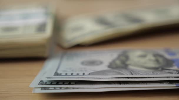 Γκρο πλαν του businessmans τα χέρια μετρώντας εκατοντάδες λογαριασμούς δολαρίων σε ένα τραπέζι — Αρχείο Βίντεο