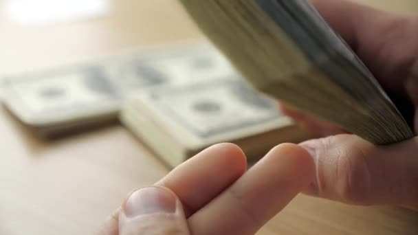 Close-up of businessmans hands counting hundred dollar bills at a table — Stock Video