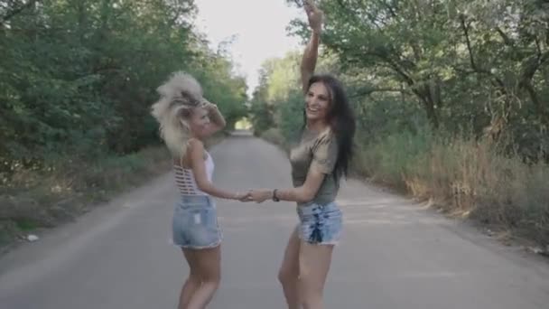 Due migliori amici sexy ragazze calde runnung e divertirsi insieme su una strada a foresta o parco . — Video Stock