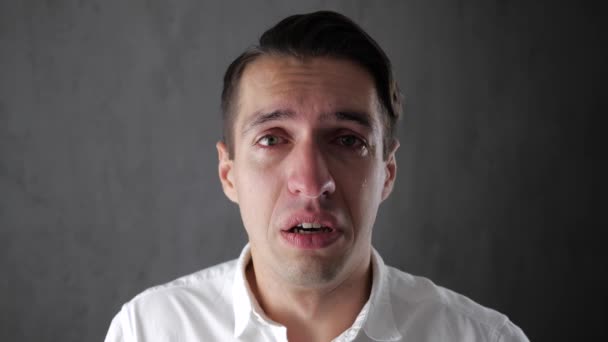 目に涙を浮かべて泣く悲しい男の肖像画。泣いて落ち込んでいるビジネスマン。絶望の中で男. — ストック動画