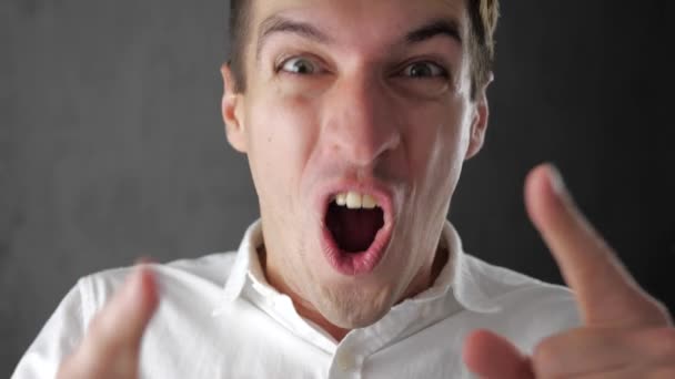 Portrait d'un jeune homme étonnant en chemise blanche. Victoire soudaine ou succès — Video