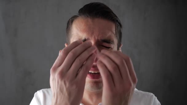 Mladý muž v zoufalství pláče, zakrývaje si tvář rukou. Podnikatel, pláč se slzami. Kolaps podnikání. — Stock video
