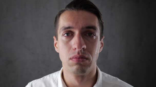 彼の顔に涙を浮かべてカメラを見て悲しそうな人の肖像画。絶望の中で男. — ストック動画