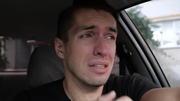 Грустный отчаявшийся мужчина плачет в машине — стоковое видео