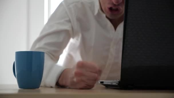 Кулак разъяренного бизнесмена бьет по столу в офисе в замедленной съемке. Чашка чая пролилась на стол — стоковое видео