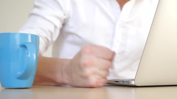 Der gestresste Geschäftsmann schlägt wütend mit der Faust auf den Tisch. verschütteter Tee aus der Tasse auf dem Laptop. den Laptop mit Wasser füllen. — Stockvideo