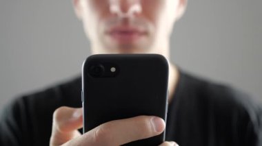 Genç adam akıllı telefon, Internet tarama ya da sosyal ağlar denetimi kullanarak closeup