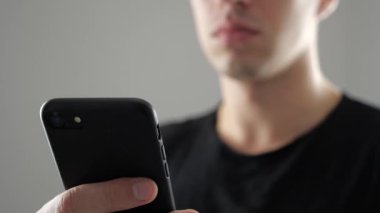 Genç adam akıllı telefon, Internet tarama ya da sosyal ağlar denetimi kullanarak closeup