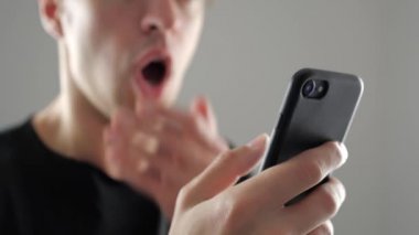 Adam fena halde şaşırttı ve smartphone bakarak şok. Kötü haber.