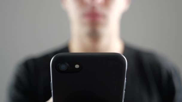 Closeup mladíka pomocí Smartphone, procházení Internetu nebo podívat na sociální sítě