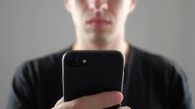 Genç adam akıllı telefon, Internet tarama ya da sosyal ağlar denetimi kullanarak closeup