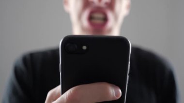 Kızgın adam Smartphone kullanarak. Öfkeli adam smartphone ile el bağırıyor