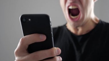 Adam ile smartphone içinde okuduğu haber kızgındır. Kızgın adam akıllı telefon kullanır.