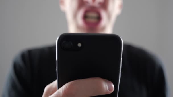 Homem irritado usando Smartphone. Furioso gritando homem com smartphone na mão — Vídeo de Stock