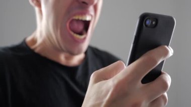 Adam ile smartphone içinde okuduğu haber kızgındır. Kızgın adam akıllı telefon kullanır.